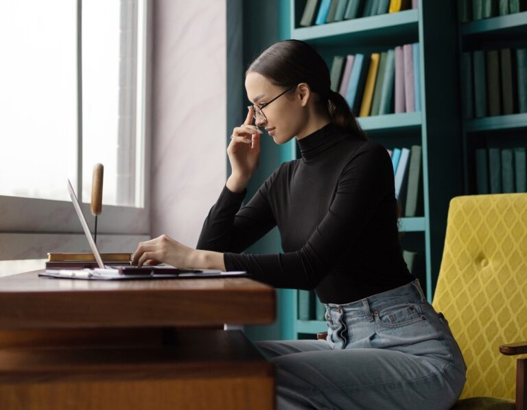 A female designer works in an office, uses a laptop computer workplace coworking space